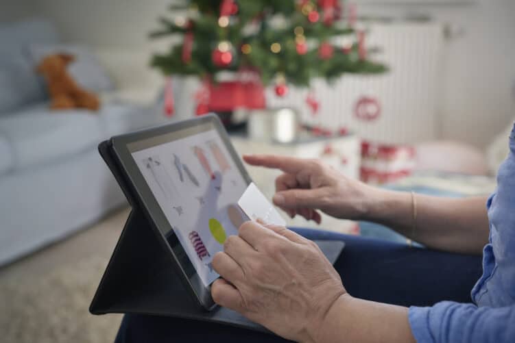 ine Person shoppt an einem Tablett und hält die Kreditkarte bereit für die Bezahlung