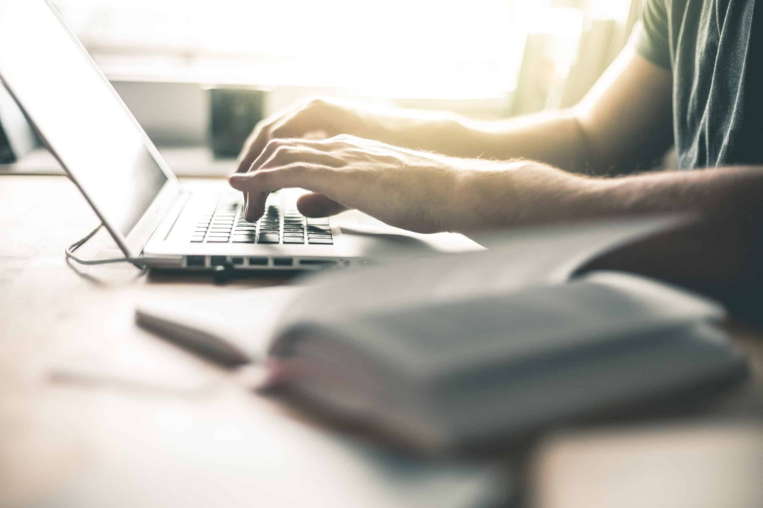 Person macht eine Keyword-Recherche an einem Laptop im Homeoffice oder Büro.